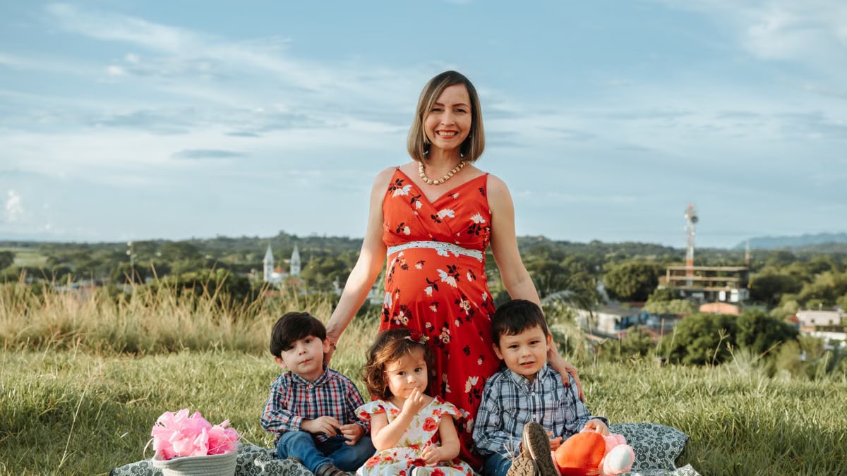 A happy family enjoying a picnic outdoors in La Dorada, Colombia, with a lush landscape in the background.